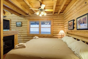 Relax in this serene bedroom with a large bed, wooden ceiling, and ceiling fan.