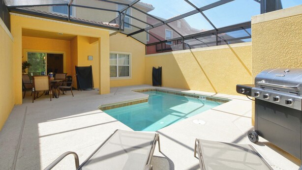 An indoor swimming pool with a glass ceiling, a barbecue grill, and lounge chairs. - Paradise Palms | 2 King Beds | Private Splash Pool & BBQ | Dog Friendly (Kissimmee)