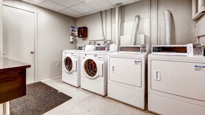 A laundry room with multiple washing machines, a drying machine, and a wooden counter. - Walk from Park City Lifts to Heated Pool/Hot Tub Managed by Park City Lodging (Park City)