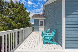 A wooden deck with a white railing, a small door, and two turquoise Adirondack chairs. - Fish-n-Ships: Oceanside, Spa, Shared Pool, Pets OK (Nags Head)