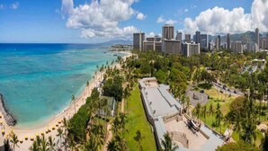 A coastal cityscape with a beach, palm trees, and a mix of modern and older buildings. - Airy, Casual Ocean View Suite w/Upgraded Kitchen, Free WiFi-Waikīkī Shore 1406 (HONOLULU)