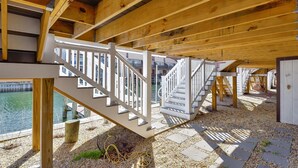 A wooden deck with a white railing, leading to a staircase.