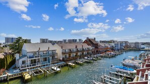 A marina with docked boats and a row of waterfront buildings.