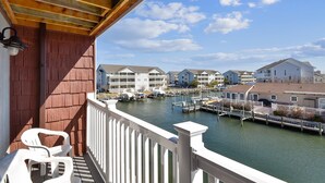 A balcony with a view of a marina and waterfront buildings.
