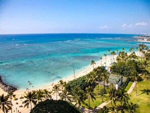 A beach with clear turquoise waters, palm trees, and a sandy shore. - Home Away from Home w/Pacific View, Chic Kitchen, Free WiFi–Waikīkī Shore #1410 (HONOLULU)