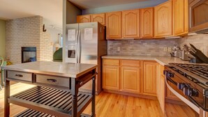 A modern kitchen with wooden cabinets, a stainless steel refrigerator, a built-in oven, and a gas stove. - Spacious Home: Hot Tub, Serene Forest (Breckenridge)