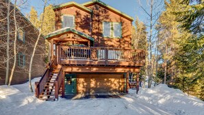 A two-story log cabin with a balcony, a staircase, and a garage. - Spacious Home: Hot Tub, Serene Forest (Breckenridge)