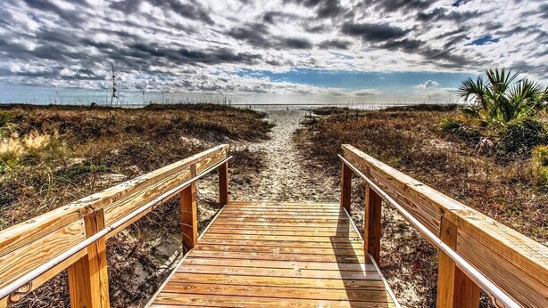 A wooden boardwalk leading to a beach with a cloudy sky. - Amazing Oceanfront View with Heated Pool! Steps from the Beach (Hilton Head Island)