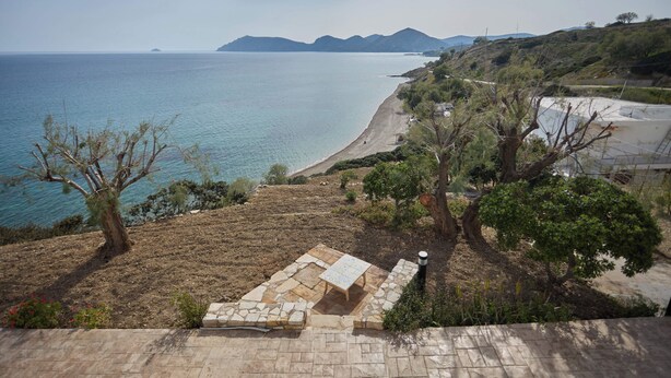 A coastal landscape with a stone patio, a view of the sea, and distant mountains. - A BALCONY WITH AMAZING SEA VIEW (CHIOS)