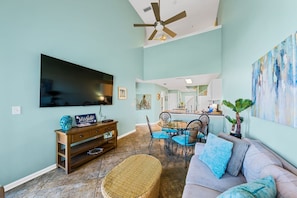 A living room with a TV, sofa, and dining area.