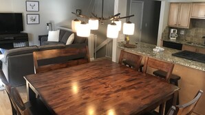 Uma cozinha moderna com bancadas de granito, armários de madeira e máquina de lavar louça embutida.