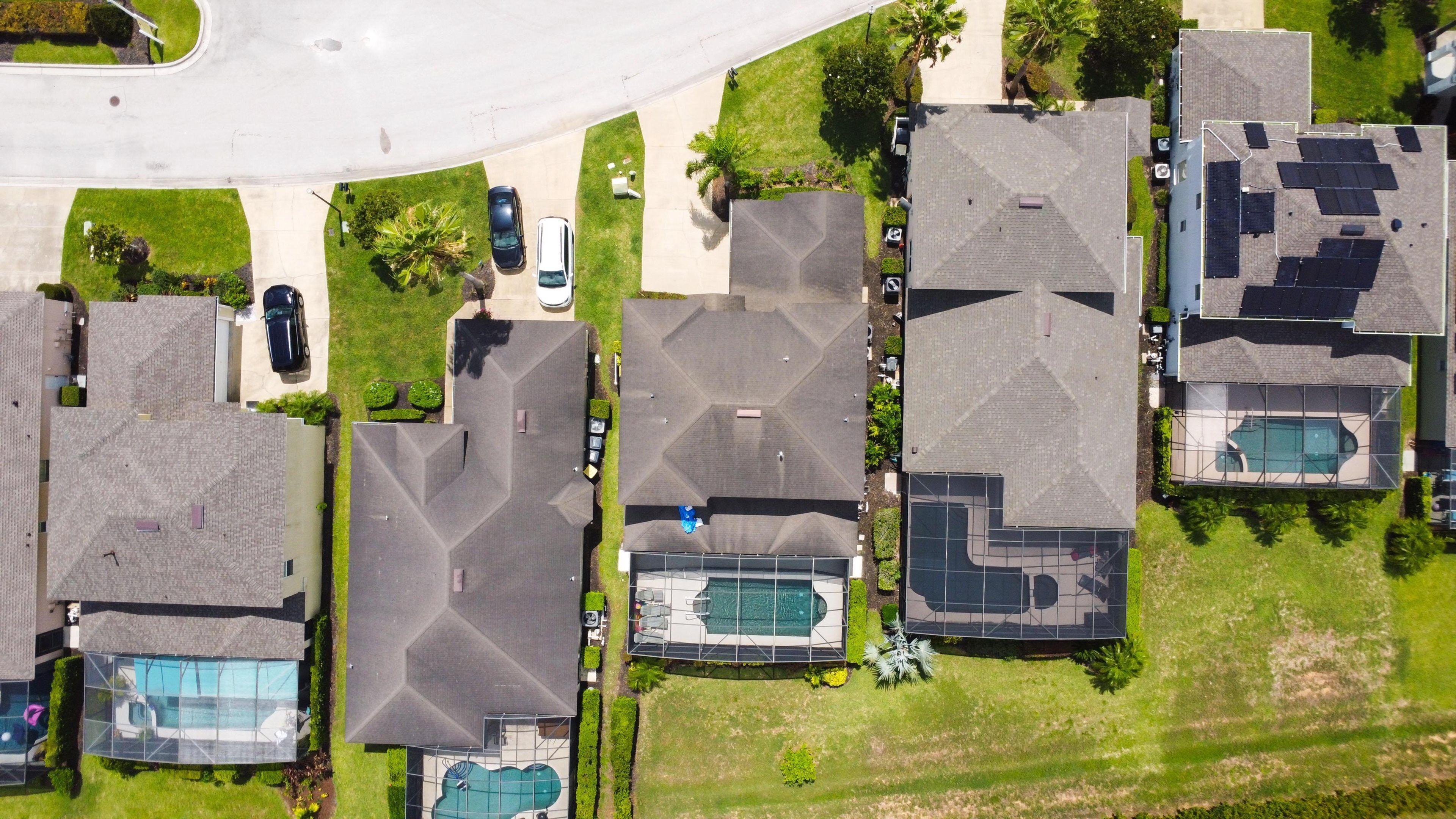 Una zona residencial con varias casas, cada una con piscina y terraza cubierta.