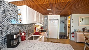 Uma cozinha moderna com bancada de mármore, máquina de café e forno embutido.