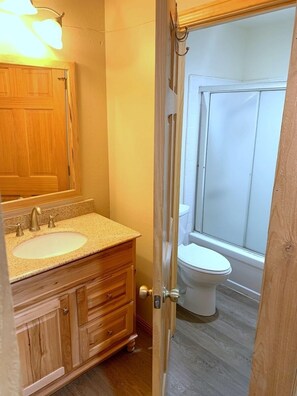 Bathroom features a double sink, toilet, and ample storage.