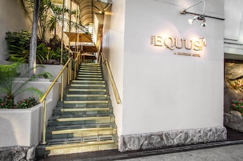 A hotel room with a bed, a desk with a lamp, a coffee maker, and a mirror reflecting the room. at The Equus