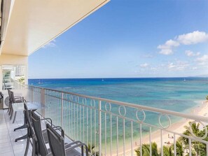 A balcony with a view of the ocean and beach.