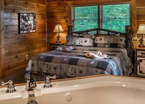 Relax in a charming bedroom with a large bed, wooden headboard, and rustic wooden walls.
