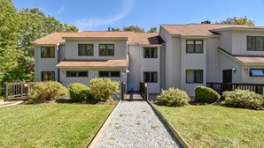 A two-story residential building with a gravel pathway leading to the entrance.