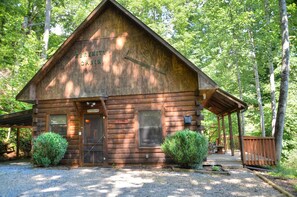 A rustic cabin named 'Serenity Cabin' with a wooden exterior, a front door, and a small porch. - 2BR cabin in Bryson City with hot tub, fireplace, WiFi, and mountain views. Free train and rafting (Bryson City)