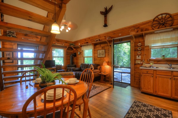L’intérieur d’un chalet rustique comprend un coin repas, un salon et une cuisine.