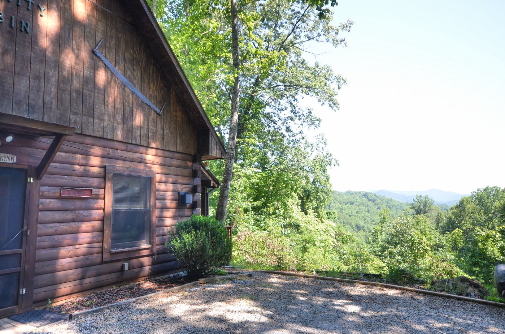 A wooden cabin with a large window, a door, and a sign that reads 'Welcome.'