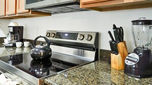 Eine Küche mit Herd, Mikrowelle, Kaffeemaschine, Wasserkocher und Mixer.