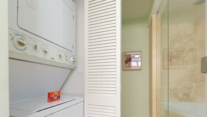 Ein Waschbereich mit Waschmaschine und einem Beutel Waschmittel Tide.