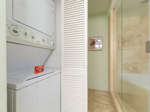 Een wasruimte met een wasmachine en een doos wasmiddel van Tide.