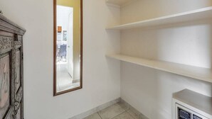 A corner of a room with a white wall, a mirror, and a white shelf unit. - Families Love the View and Fun Decor! Free WiFi, Full Kitchen–Waikīkī Shore #PH05 (HONOLULU)