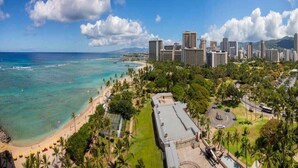 A coastal cityscape with a beach, palm trees, and high-rise buildings. - Families Love the View and Fun Decor! Free WiFi, Full Kitchen–Waikīkī Shore #PH05 (HONOLULU)