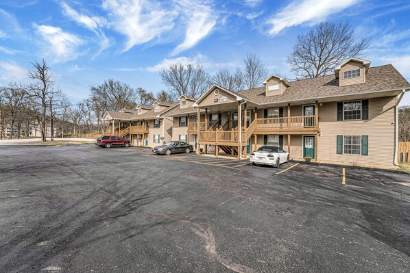 A multi-story hotel with a covered front porch and a parking lot. - Cozy Lake Front Condo (Branson)