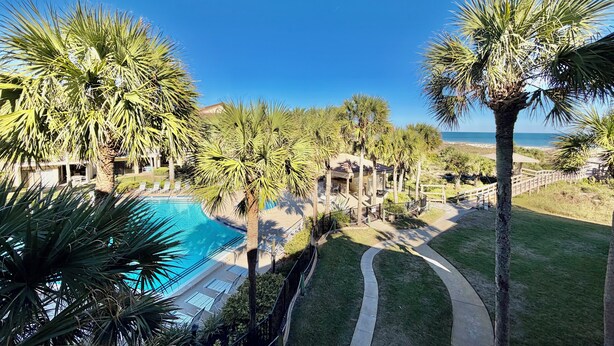 A resort with a swimming pool, palm trees, and a view of the ocean. - FREE ACTIVITIES & A gorgeous ocean view unit ready for your enjoyment. (Saint Augustine)