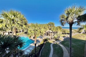 A resort with a swimming pool, palm trees, and a view of the ocean. - FREE ACTIVITIES & A gorgeous ocean view unit ready for your enjoyment. (Saint Augustine)