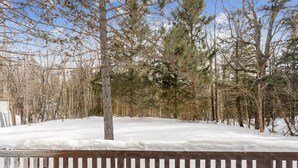 A snowy landscape with a wooden fence and trees.