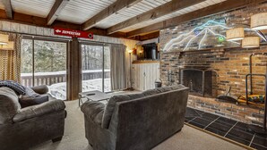 A cozy living room with a fireplace, a sofa, and a television.