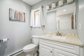 Une salle de bain avec des toilettes, un lavabo et un miroir.