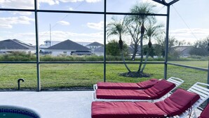 Ein Poolbereich mit Liegestühlen und Blick auf Häuser und Bäume.