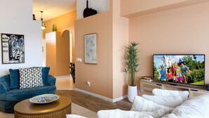 Ein modernes Wohnzimmer mit einer Couch, einem Couchtisch und einem Fernseher.