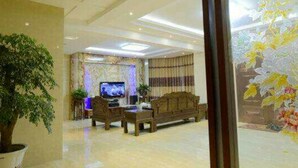 Una sala de estar moderna con televisor, sofá y mesa de centro.