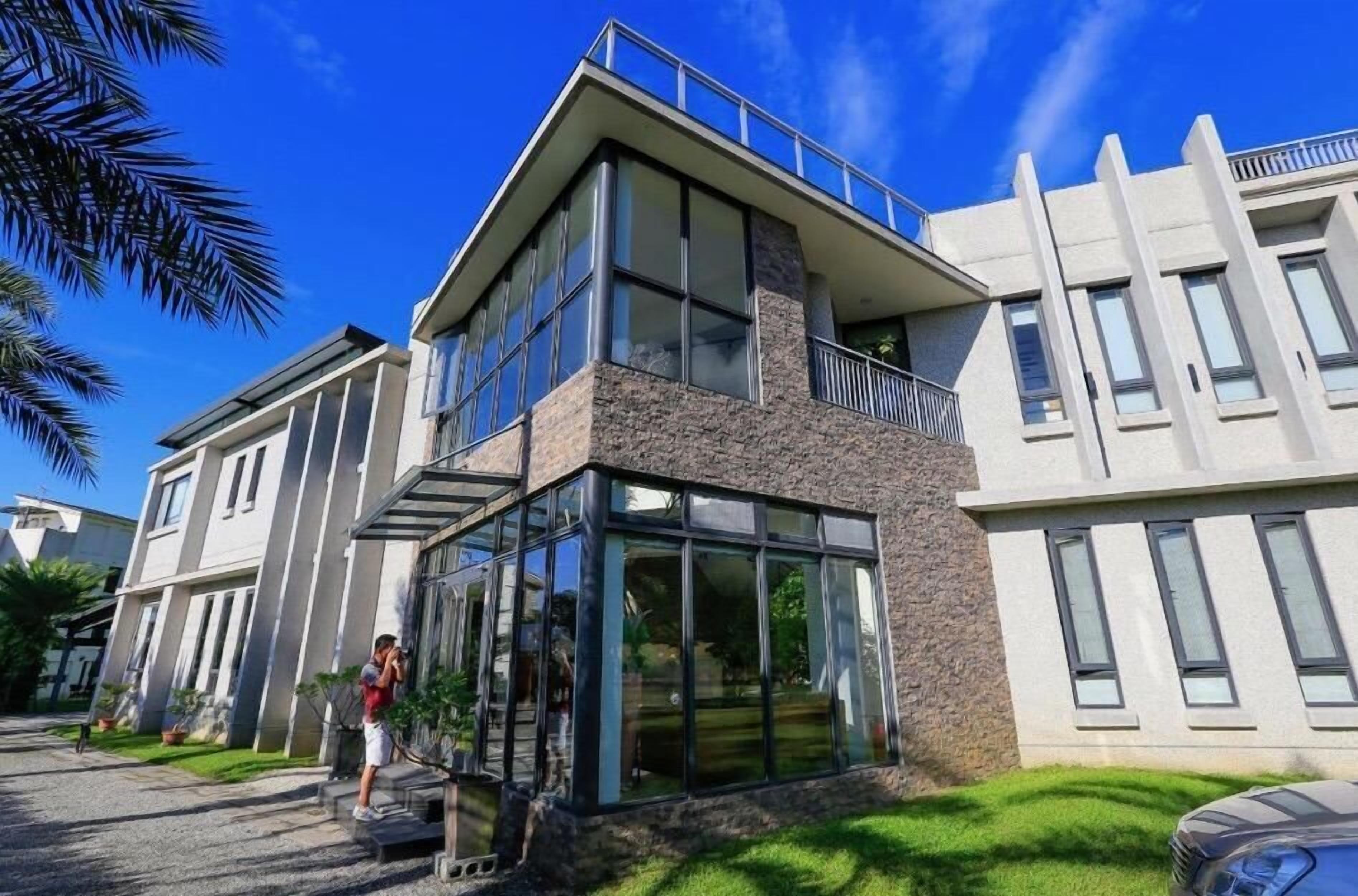 A modern two-story building with large windows and a balcony.
