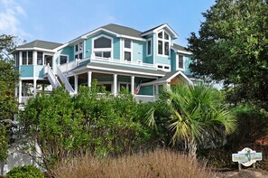 A two-story house with a balcony, surrounded by lush greenery. - Bermuda Banks: Private Pool, Spa, Pet-friendly (Corolla)