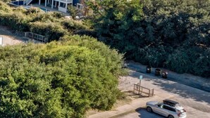 Une zone résidentielle côtière avec des maisons, une route et une voiture.