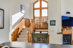 Een trap met houten leuningen die naar een balkon op de tweede verdieping leidt.