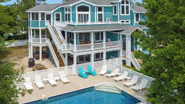 Une maison à deux étages avec un balcon et une piscine.