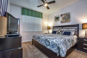 A bedroom with a bed, a ceiling fan, a window with blinds, a dresser, and wall art. - Spacious 5BR Paradise Palms Home with Private Pool & Loft (Kissimmee)