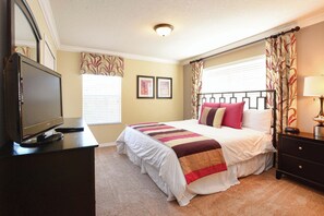 A hotel room with a bed, a TV, a dresser, and a nightstand. - Dog-Friendly · Dual Master Suites · Private Pool · 5 Min to Disney (Kissimmee)
