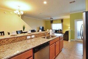 Una cocina con encimeras de granito, lavavajillas y armarios de madera.