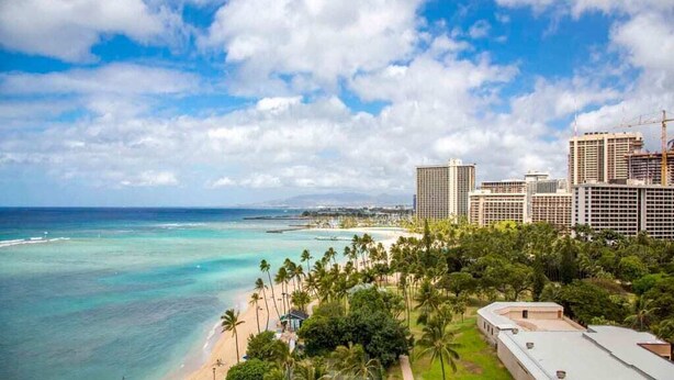 A coastal hotel with a beach view, multiple high-rise buildings, and a clear sky.