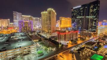 A cityscape at night with illuminated buildings, including a hotel with a sign.