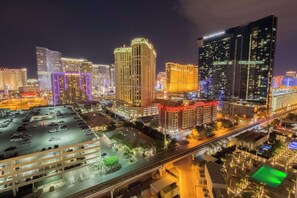 A cityscape at night with illuminated buildings, including a hotel with a sign.